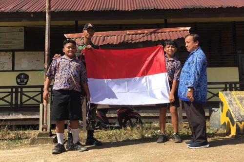 Satgas Yonarmed 10 Kostrad Berikan Bendera Merah Putih kepada SDN di Perbatasan Negara RI-Malaysia